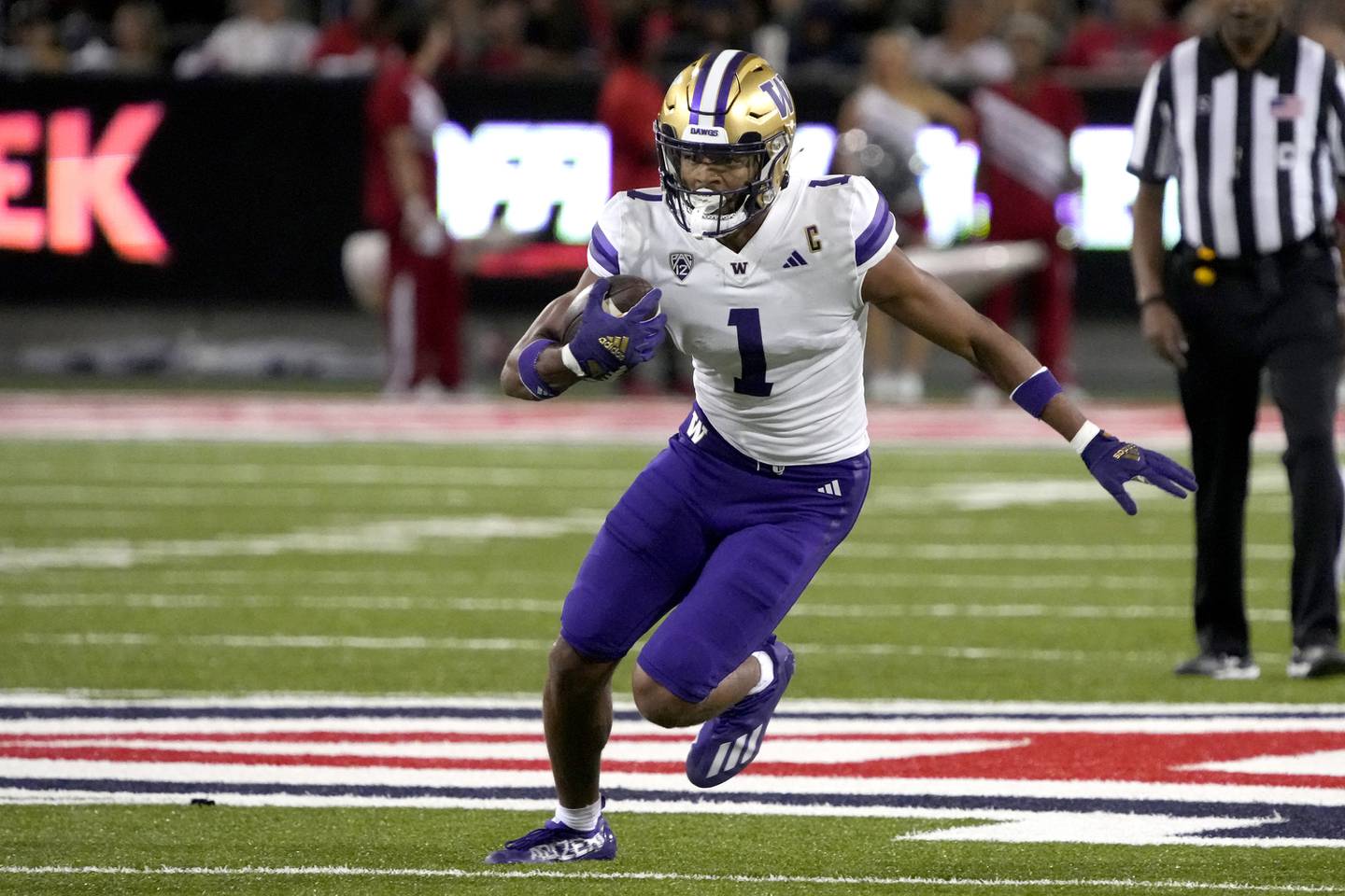 FILE - Washington wide receiver Rome Odunze (1) runs the ball in the first half of an NCAA college football game against Arizona, Sept. 30, 2023, in Tucson, Ariz. Odunze, who played the middle portion of the year with a broken rib and finished the year as a first-team All-American on seemingly every list, will face No. 3 Texas in the Sugar Bowl Monday, Jan. 1, 2024. (AP Photo/Rick Scuteri, File)