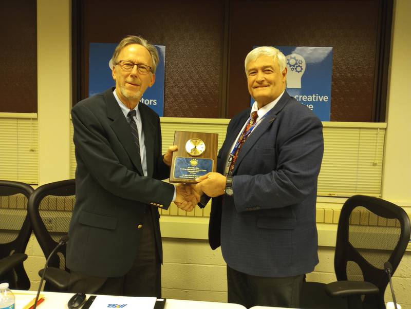 Geneva District 304 School Board President Larry Cabeen (left) presents outgoing Superintendent Kent Mutchler with a plaque and thanks for his 17 years of service.