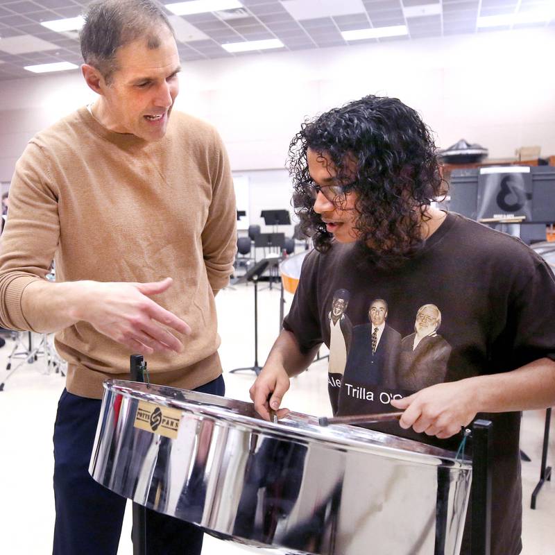 Jaden Teague-Núñez, 16, a sophomore at DeKalb High School, with the steelpan as Steve Lundin, the schools director of bands, looks on Monday, March 18, 2024, in the band room at the school. Teague-Núñez won first place in the Chicago Symphony Orchestra’s Young Artists Competition and will appear as a soloist in a CSO youth concert during the 2024-25 season.