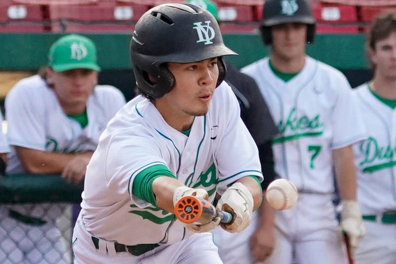 York's Austin Grzywa (4) bunts the ball against McHenry during a class 4A Kane County supersectional baseball game at Northwestern Medicine Field in Geneva on Monday, June 3, 2024.