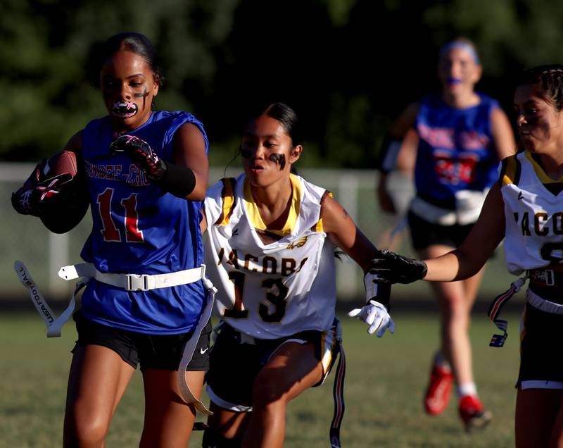 Dundee-Crown’s Taiyah Boddie Thomas, left, runs the ball as Jacobs’ Isa Saez pursues the play in varsity flag football on Tuesday, Sept. 3, 2024, at Dundee-Crown High School in Carpentersville.