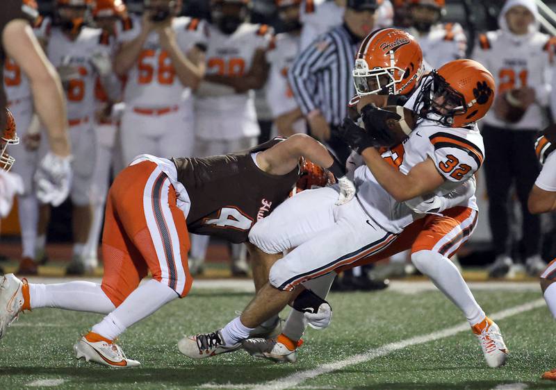 Wheaton Warrenville South's Max Schlegel (32) is wrapped as he spins for more yards during the IHSA Class 7A playoffs Saturday October 28, 2023 in Arlington Heights.