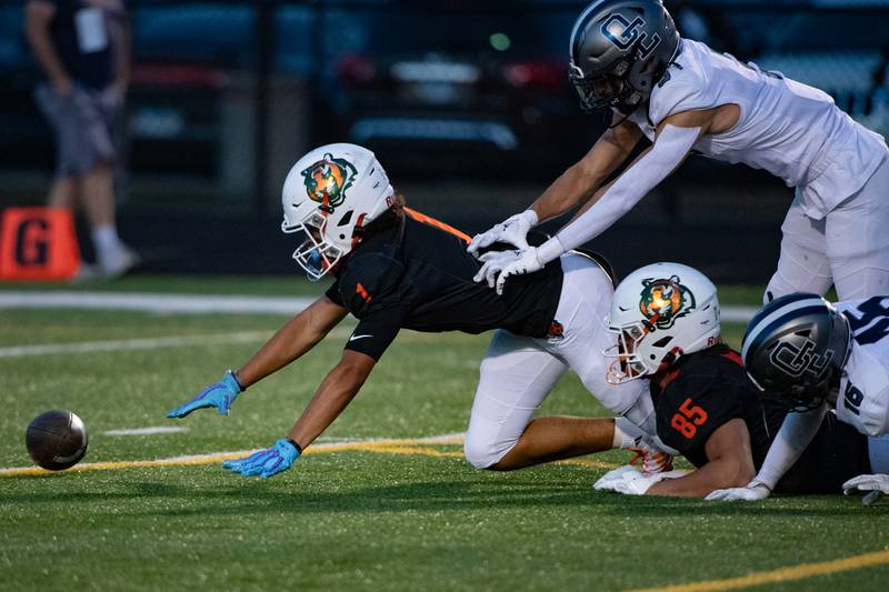 Plainfield East's Jayden Cawthon and Oswego East's Juan Cepeda dive for control of a fumbled punt return during a game on Thursday Sept. 12, 2024 at Plainfield East High School