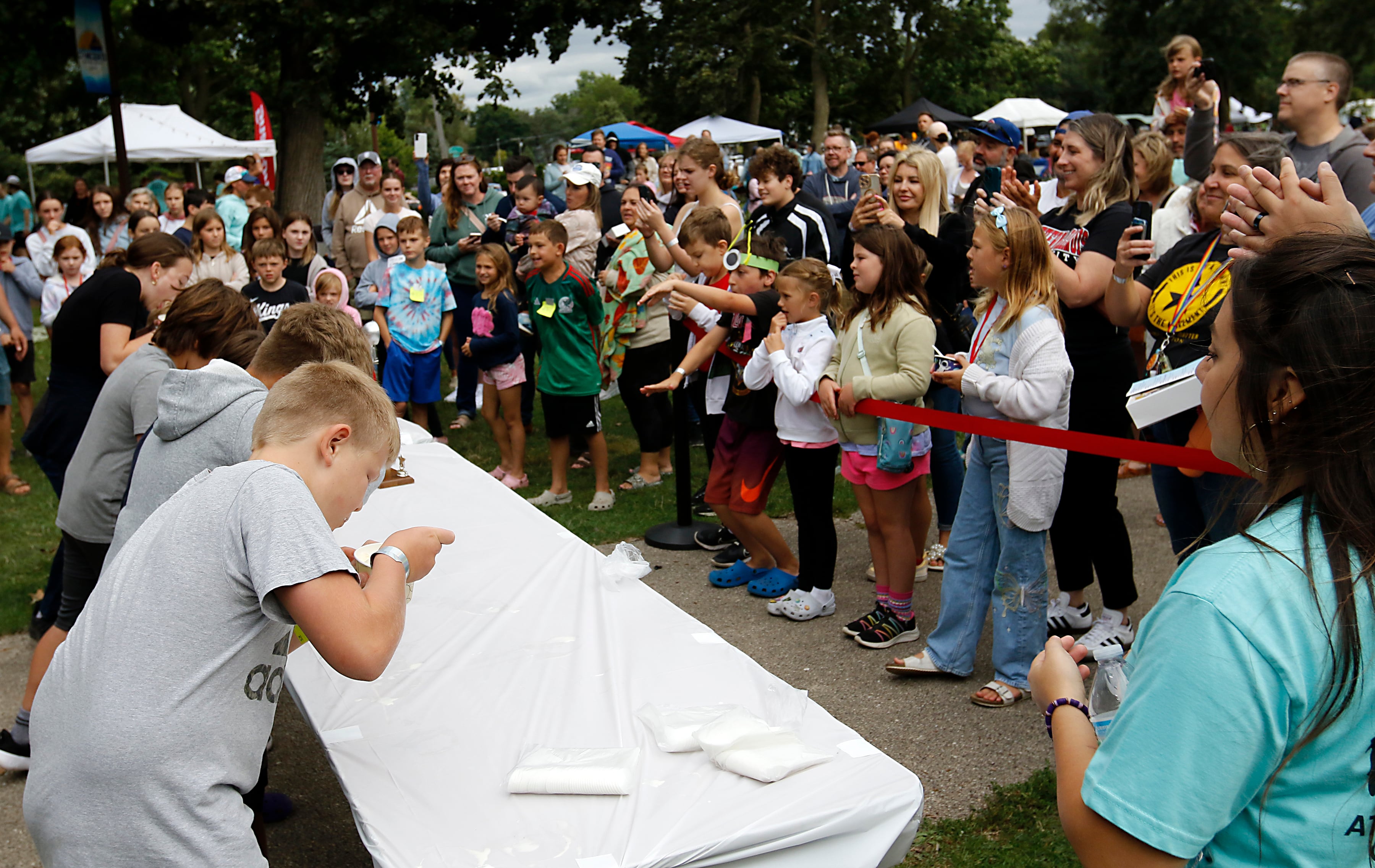 People wait for the cheer for contestants in the Brain Freese Ice Cream Eatin’ Contest during the Ice Cream Fest on Friday, Aug. 9, 2024, at Crystal Lake’s Main Beach.  The second annual event featured music, ice cream venders and the ice cream eating contest.