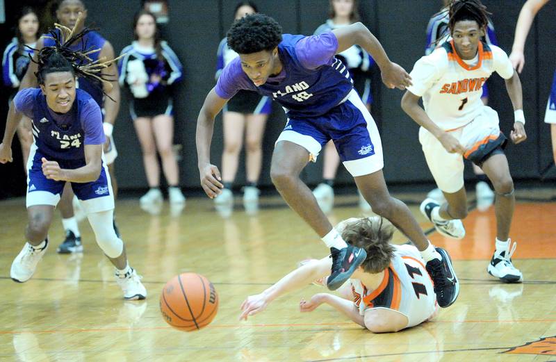 Plano's Davione Stamps (10) hops over Sandwich's Nick Michalek (11) to recover a loose ball during a varsity basketball game at Sandwich High School on Tuesday, Feb. 13, 2024.