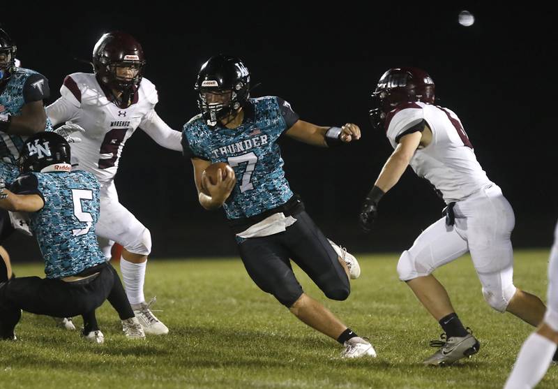 Woodstock North's Parker Halihan runs the ball between Marengo's Jacob Leidig (left)  and Caden Oine (right) during a Kishwaukee River Conference football game on Friday, Sept. 13, 2024, at Woodstock North High School.