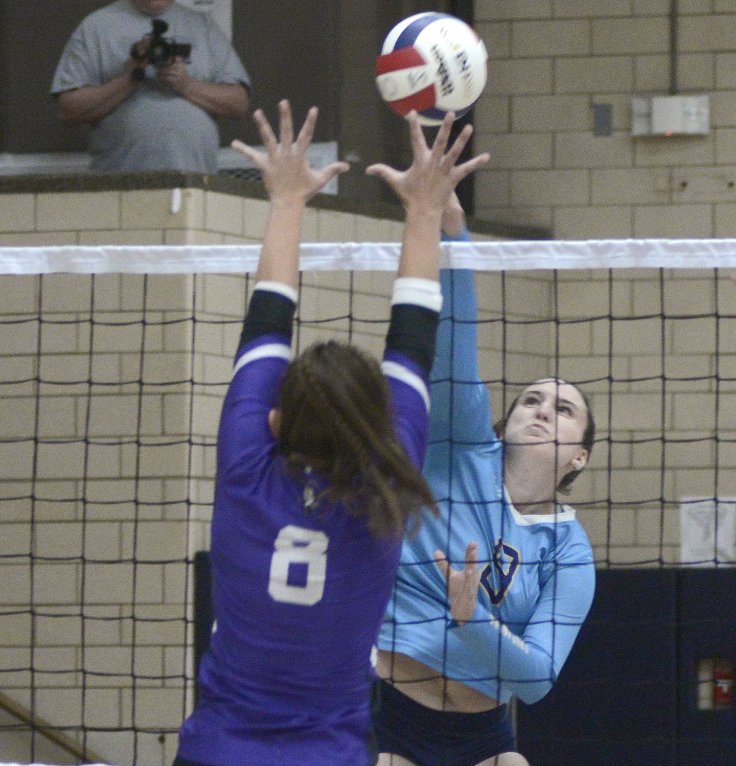 Marquette’s Makayla Backos jumps to get this shot past Lexington’s Avery Poppe in the first match Tuesday at Marquette.