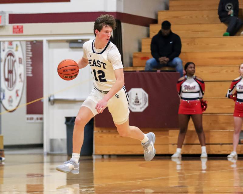 Oswego East's Ryan Johnson (12) pushes the ball during Class 4A Lockport Regional final game between West Aurora at Oswego East.  Feb 24, 2023.