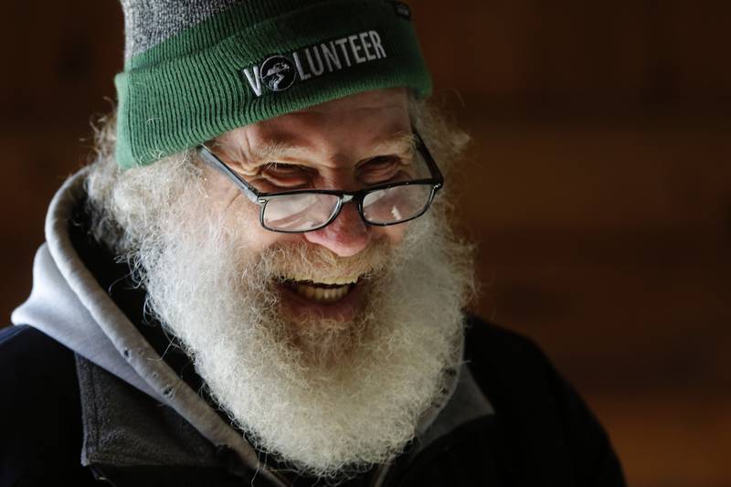 Volunteer Buck Wallace smiles as listens to a child guess how much sap is needed to make a gallon of maple syrup during the McHenry County Conservation District’s annual Festival of the Sugar Maples, at Coral Woods Conservation Area, in Marengo, on Monday, March 11, 2024.