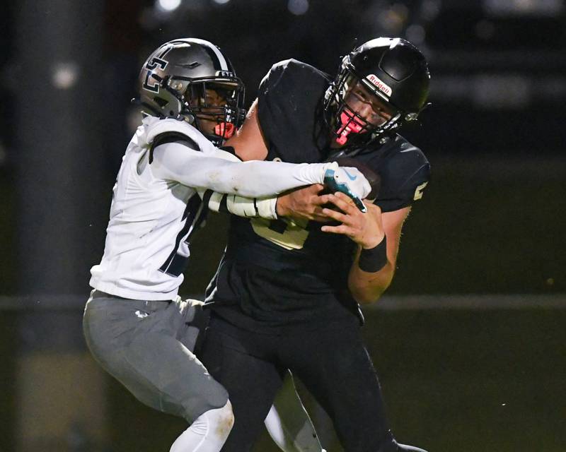 Sycamore's Kyle Prebil (5) catches a long pass during the game while being defended by Oswego East's Jamari Mckay (15) on Friday Sept. 6, 2024, held at Sycamore High School.