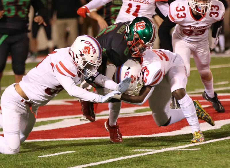 L-P's Adrian Arzola runs the ball between Ottawa defenders Tyce Kubiak and teammate Keevon Peterson on Friday, Oct. 6, 2023 at Howard Fellows Stadium.