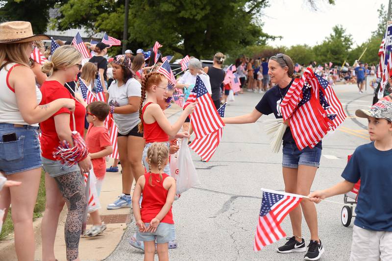 American Flags are handed out during the Yorkville Independence Day Parade on Thursday, July 4, 2024 in Yorkville.