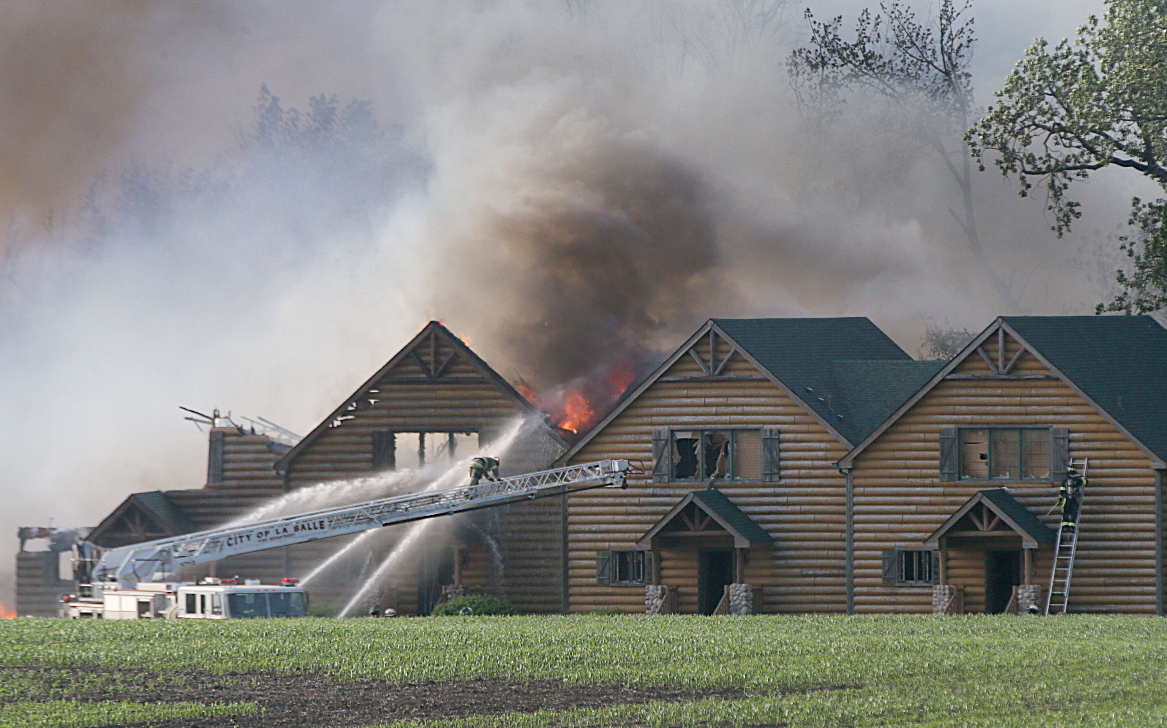 La Salle firefighters use their aerial fire truck to fight a five-alarm fire at the Grand Bear Resort on Monday, May 30, 2022 in Utica.