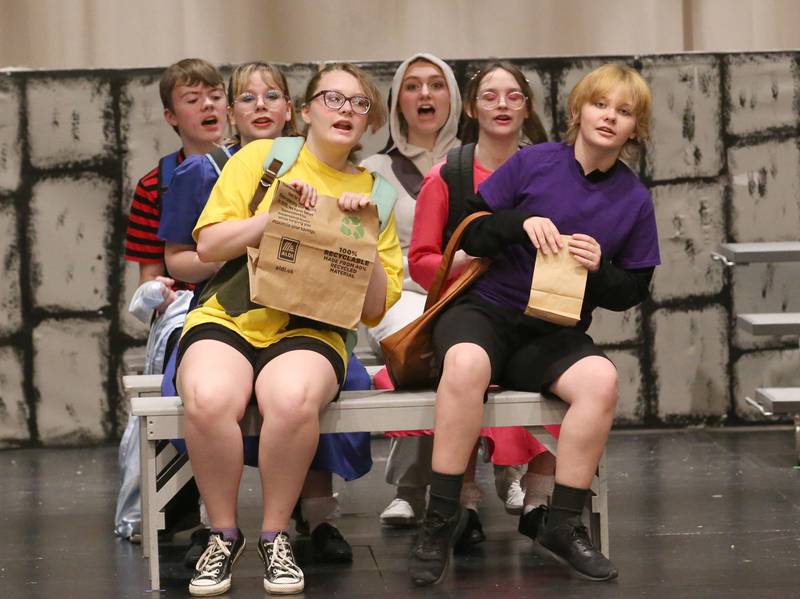 (From left) Sindney Davis as Linus, Allison Wozek as Sally, Aarow Kleckner as Charlie, Haley Campbell as Snoopy, Grace Wozek as Lucy, and Vinny Philippe as Schroeder act out a bus scene in "You're a Good Man Charlie Brown" on Thursday, March 23, 2023 at Hall High School in Spring Valley.