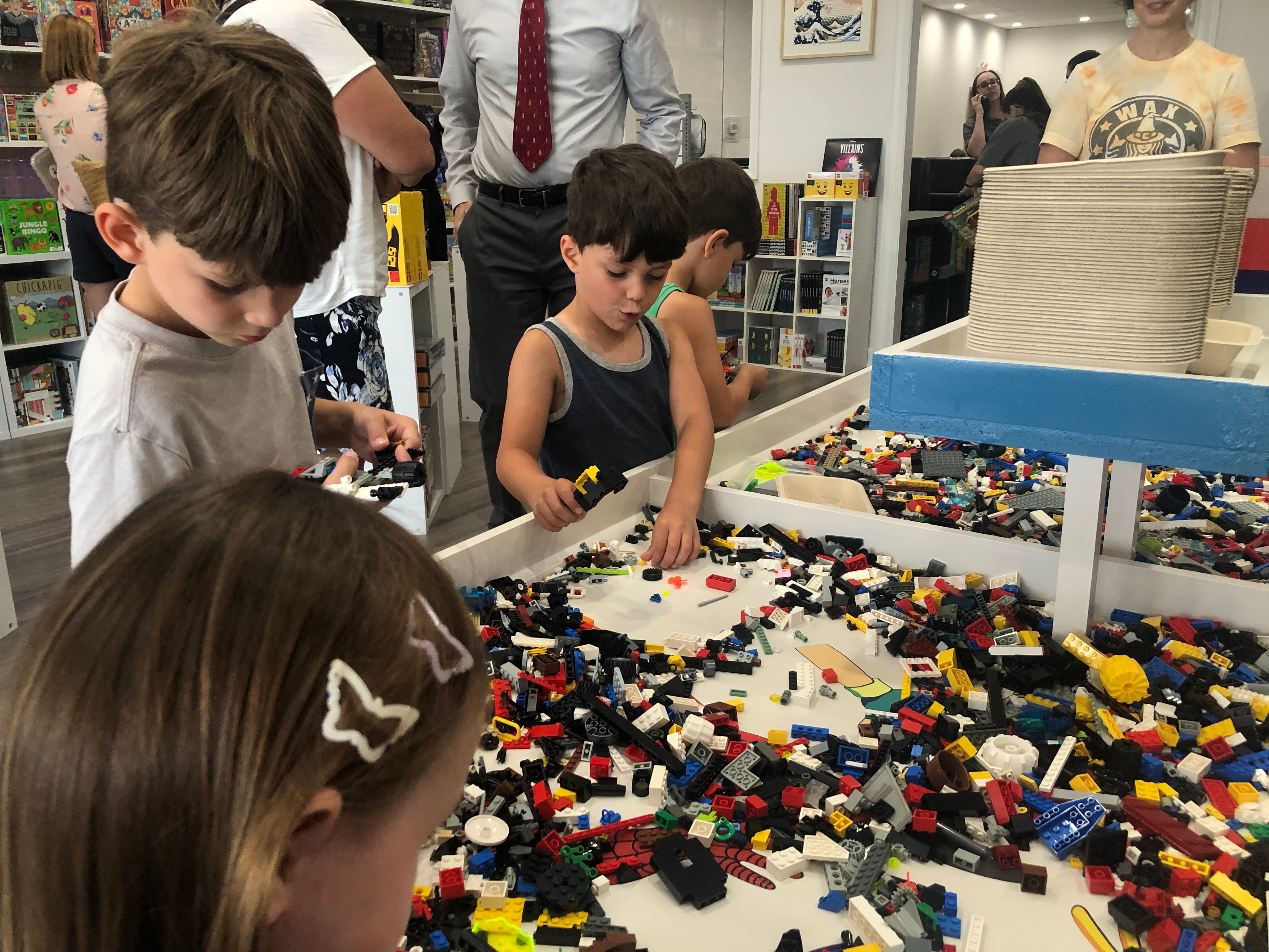 Hudson, Nolan and Bennett Beachler play at the  Lego table at The Pieceful Project in Cary on Wednesday, July 24, 2024. The store allows customers to buy, rent or have a subscription to play with the pieces they sell: Lego sets, games and puzzles.