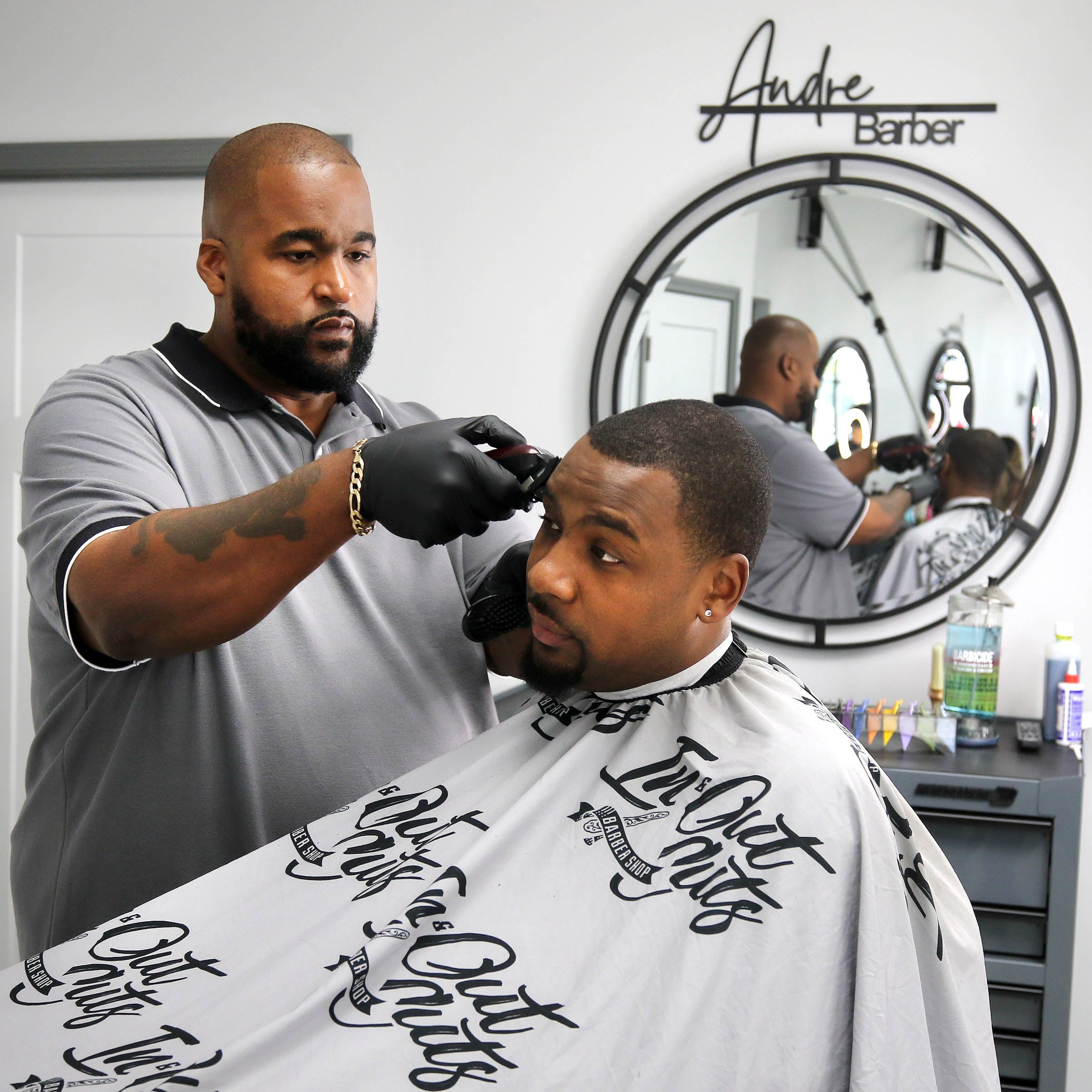 Julian McElroy gets a haircut from Andre Powell, owner of In & Out Cuts Barbershop, Friday, Aug 9, 2024, in the barbershop’s new location at 2331 Sycamore Road in DeKalb.