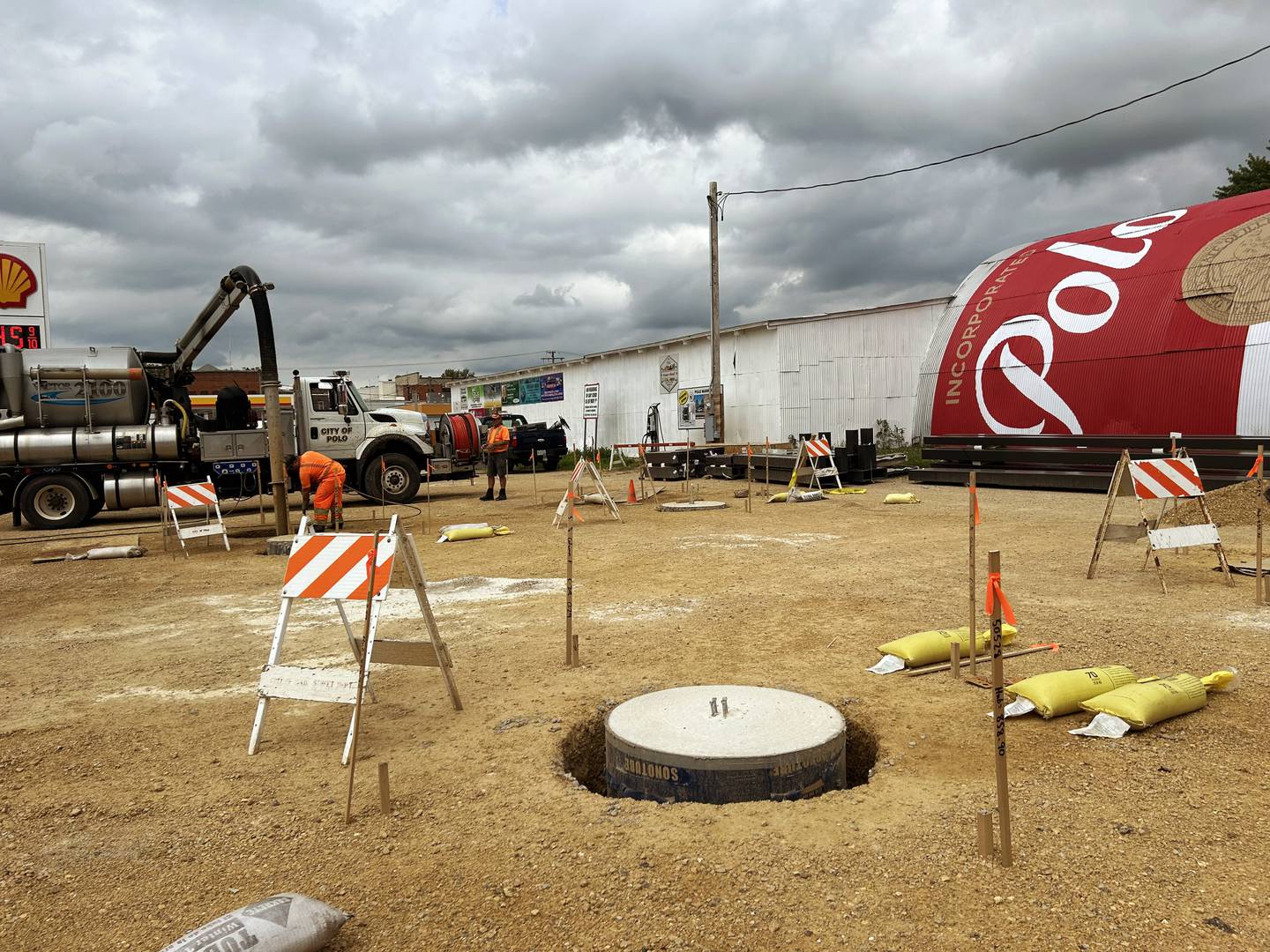 Polo city employees work to prepare the city-owned lot at 212 S. Division Ave. for the erection of two pavilions.