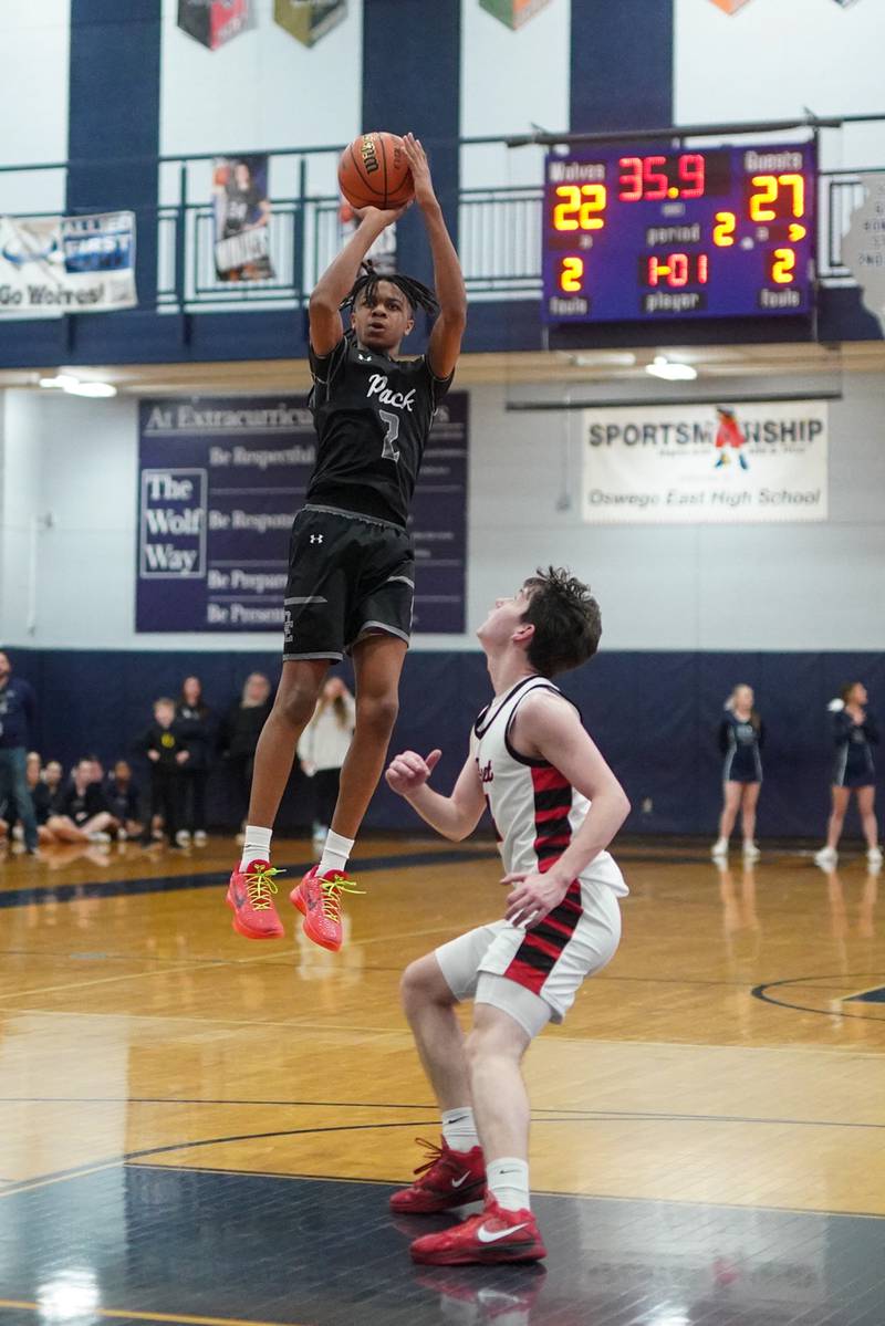 Oswego East's Mason Lockett IV (2) shoots the ball on the top of the key against Benet’s Patrick Walsh (4) during a Class 4A Oswego East regional final basketball game at Oswego East High School on Friday, Feb 23, 2024.