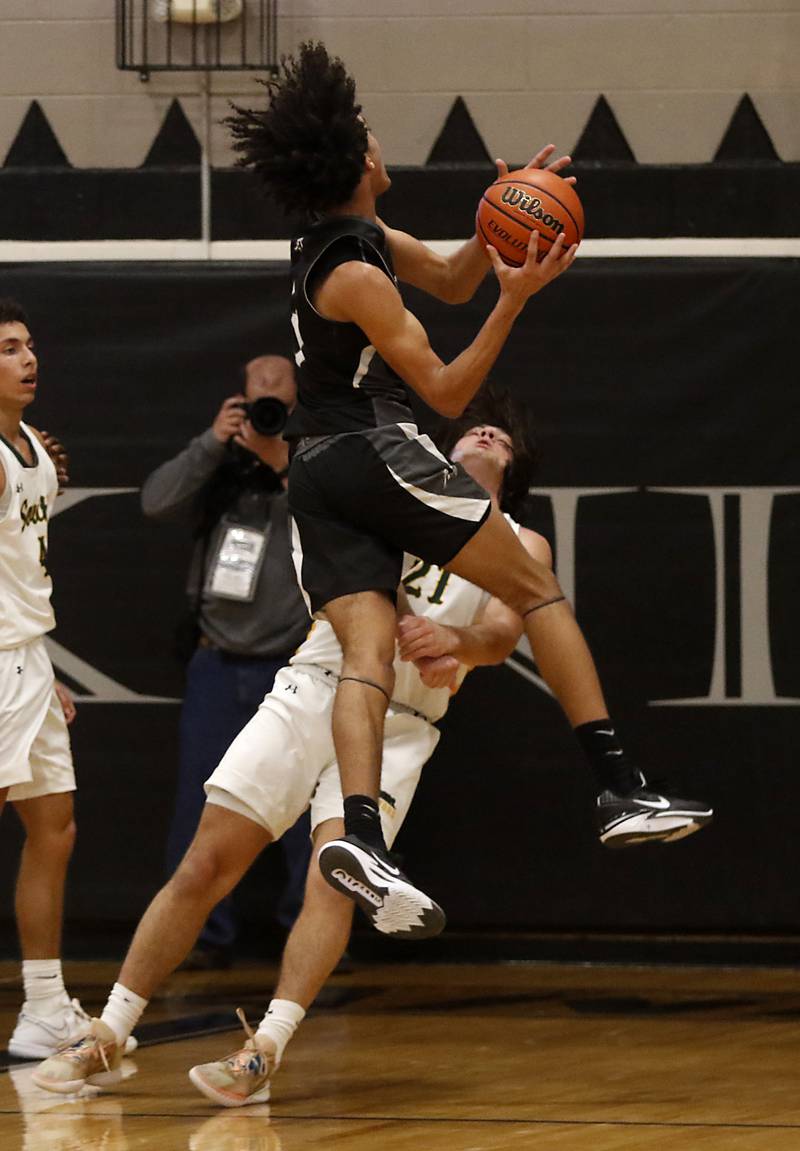 Crystal Lake South's Michael Prokos takes a charge against Kaneland's Evan Frieders as Frieders drives to the basket during the IHSA Class 3A Kaneland Boys Basketball Sectional championship game on Friday, March 1, 2024, at Kaneland High School in Maple Park.