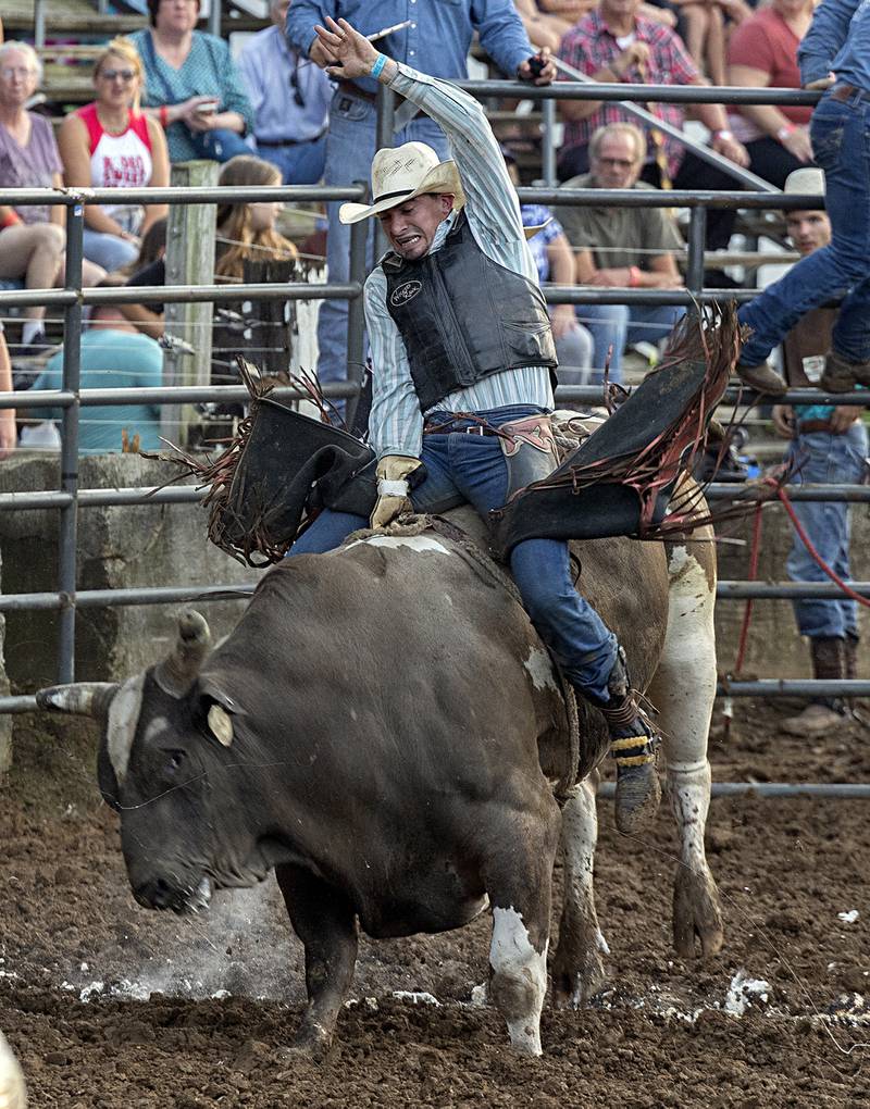 Adam McConnell looks to tame “Arrowhead” during his ride in the Rice Bull Riding and Barrel Racing event Thursday, August 11, 2023 at the Carroll County fair.