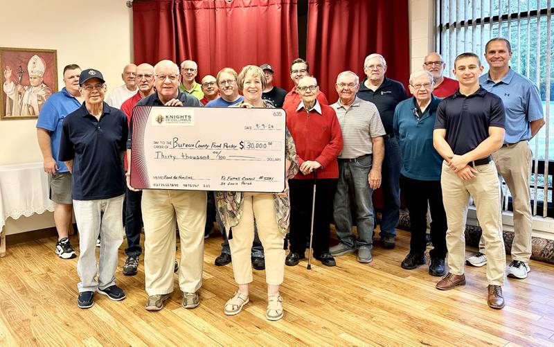 Dave Boylan, representing the Knights of Columbus, presents a $30,000 donation to Vanessa Hoffeditz, Director of Tri-County Opportunties Council, for the Bureau County Food Pantry on the behalf of an anonymous donor.