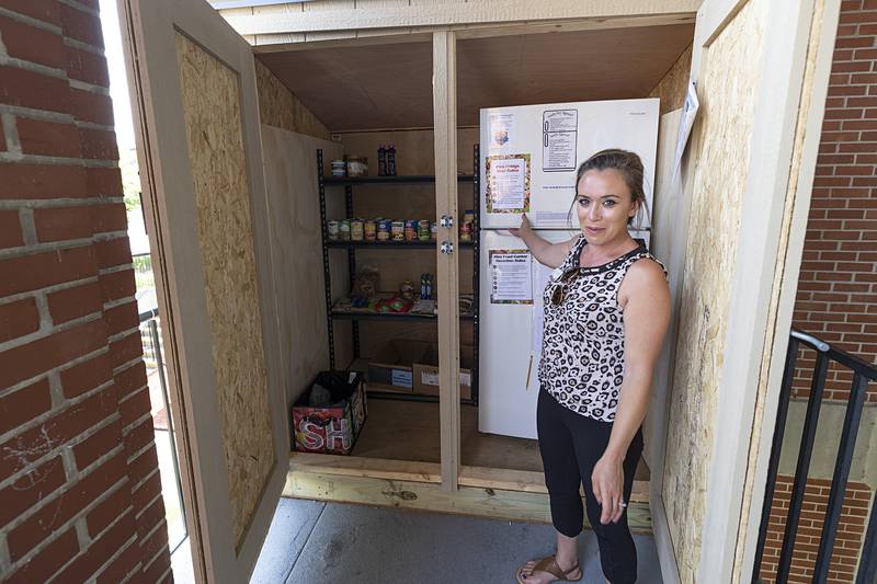 Candi Garcia, marketing coordinator for the YWCA of the Sauk Valley, displays the mini food mart Tuesday, June 25, 2024, located in the porch of the Sterling facility. The mart, one of four in the area, is open 24 hours and stocked once a week with dry goods and frozen and fresh foods.