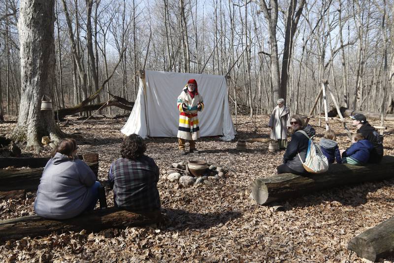 Volunteer Buck Wallace, dressed in early 1700s era clothing, talks how Native Americans discovered maple syrup while teaching about the history of maple sugaring during the McHenry County Conservation District’s annual Festival of the Sugar Maples at Coral Woods Conservation Area, 7400 Somerset Drive in Marengo. People were able to walk through the woods and learn about history of maple sugaring and the evolution of the sap collection process during the one-hour, half-mile hike through a woodland trail on Monday, March 6, 2023. The festival continues on March 11, 12 and 13, and signing up for a tour time slot is required.