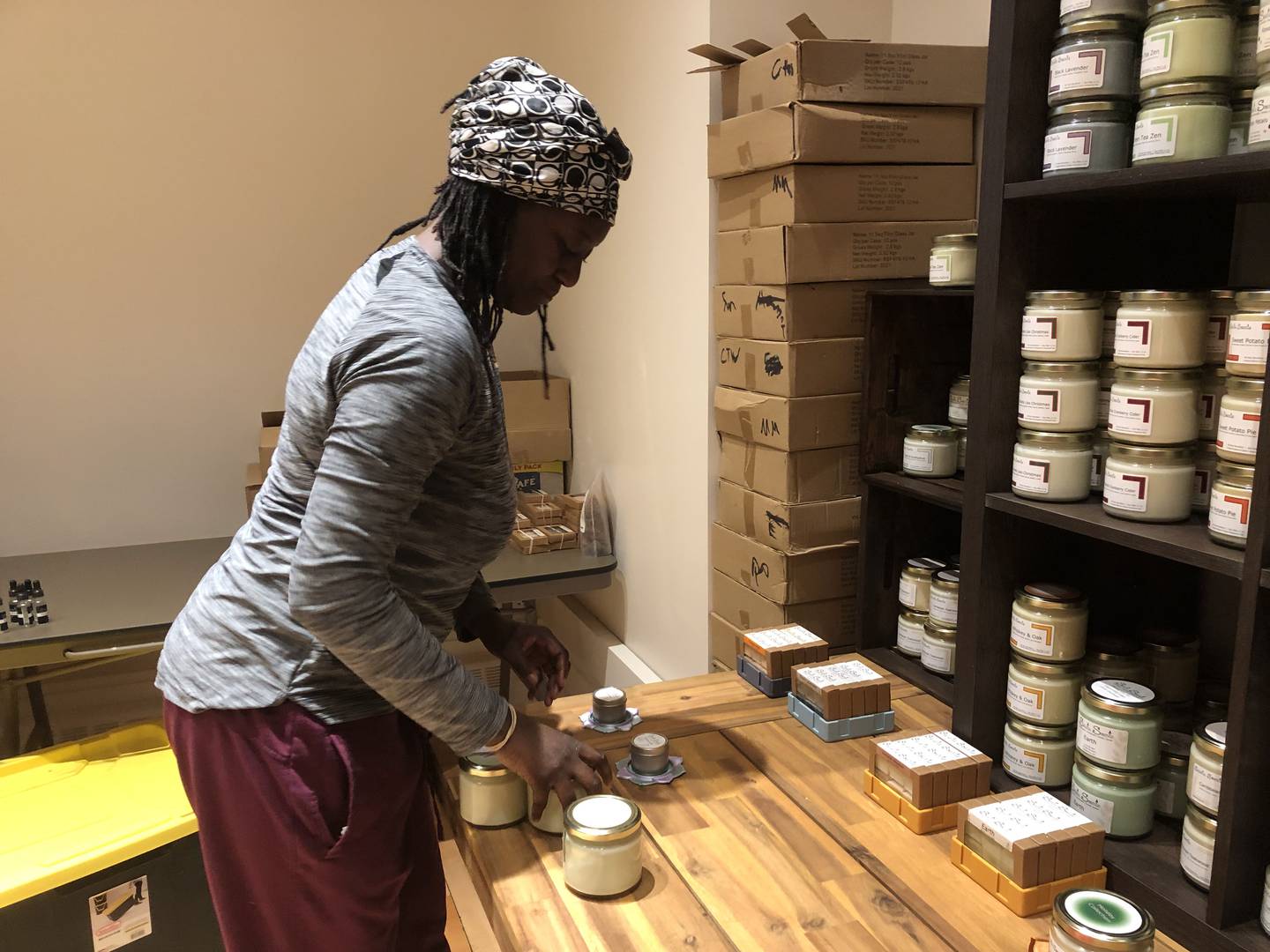 Julienne Samuels of Seleta Scents places merchandise on shelves ahead of the store's opening in 2023.