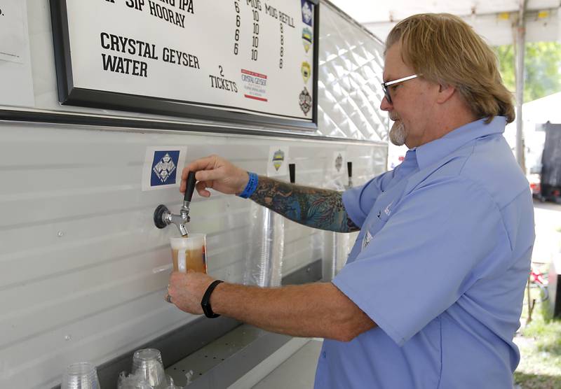 Lakeside Festival volunteer Chris Ruckoldt pours Whitsell 44, a beer produced by Crystal Lake Brewing Company especially for the festival. Ruckoldt is pictured Friday, July 5, 2024, at the festival at the Dole.