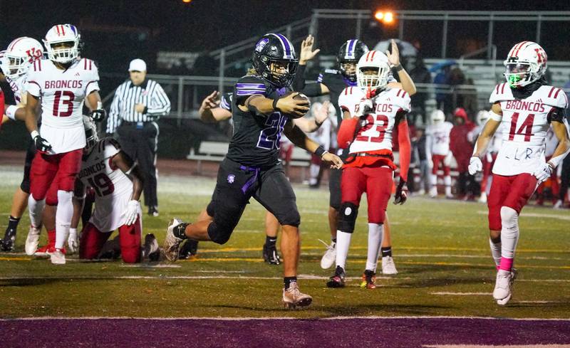 Downers Grove North's Noah Battle (20) carries the ball for a touchdown against Kenwood during a class 7A playoff football game at Downers Grove North on Friday, Oct. 27, 2023.
