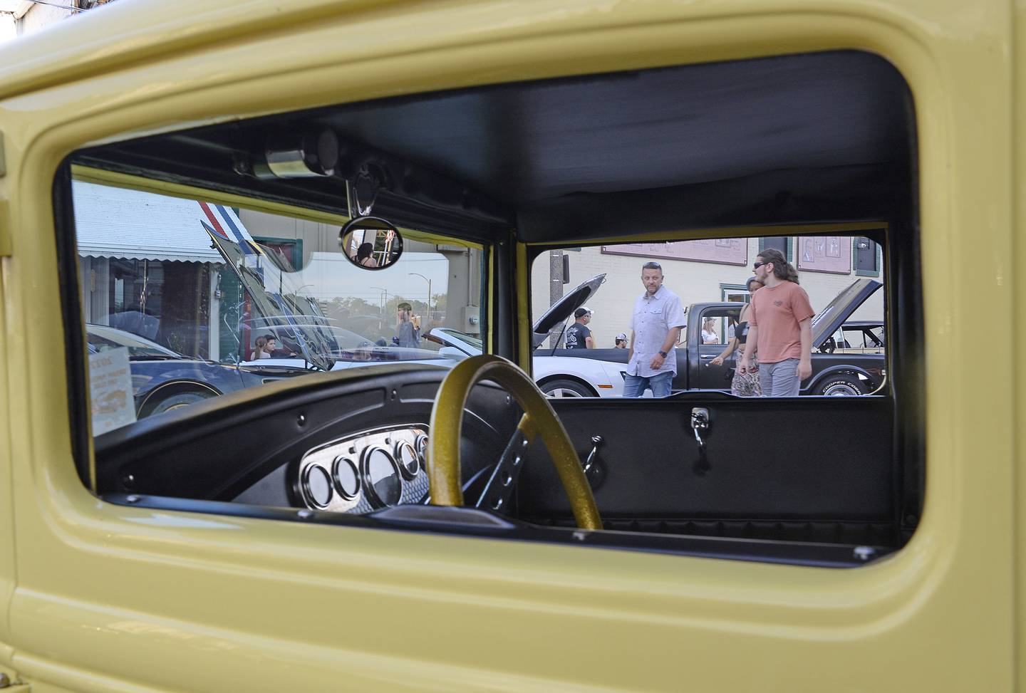 A view from the inside of a classic 1930’s vehicle as car enthusiasts stroll by during The Dream Machine Car Clubs Cruise night Saturday.