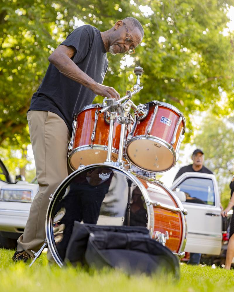 William Mason assembles the drum kit Sunday, May 26, 2024, prior to the band NBT Funk taking the stage at the Music and Arts Festival at Pulaski Park in La Salle.