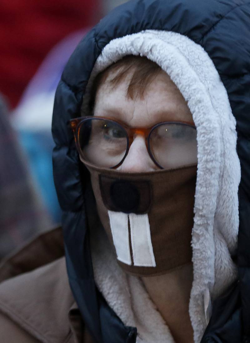 A woman in the crowd sports a groundhog mask Wednesday, Feb, 2, 2022, during the annual Groundhog Day Prognostication on the Woodstock Square.