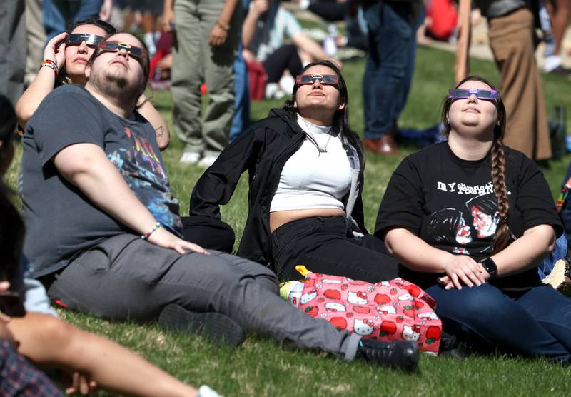 Attendees watch the eclipse Monday, April 8, 2024, at the Northern Illinois University Solar Eclipse Viewing Party behind Davis Hall in DeKalb. Attendees were treated to perfect weather to watch the rare celestial event.