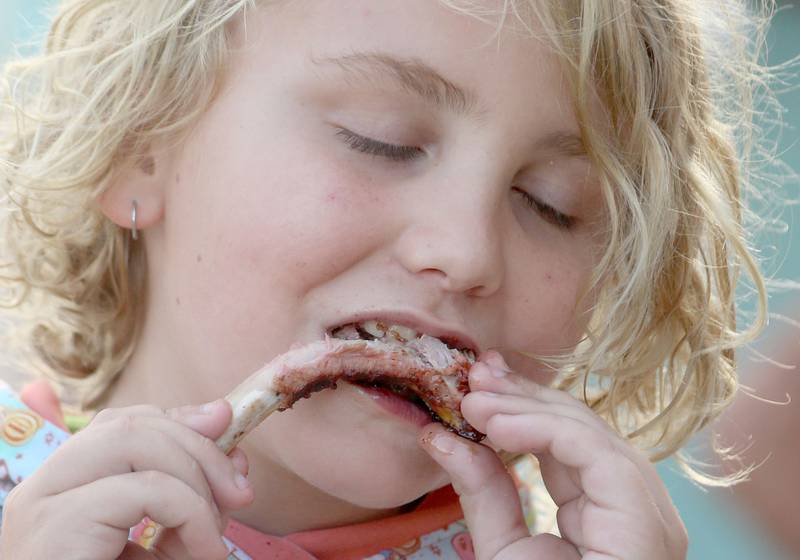 Larz Zrust of Ladd, bites into a BBQ rib during the BBQ and Blues festival on Friday, Sept. 13, 2024 downtown La Salle.