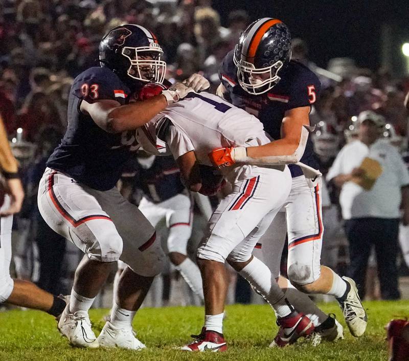 Oswego’s Christian Taylor (93) and Carson Cooney (5) hit West Aurora's Eliseo Liscano (1) behind the line of scrimmage for a loss during a football game at Oswego High School on Friday, Sept. 29, 2023.