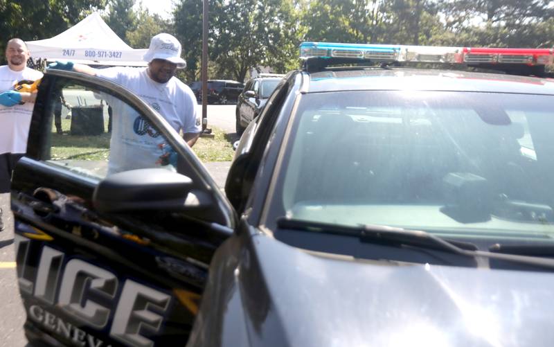 Cheyne Ngirmang of Hazardous 360 biohazard cleaning company cleans a Geneva Police vehicle on Thursday, Sept. 5, 2024 at Wheeler Park in Geneva.