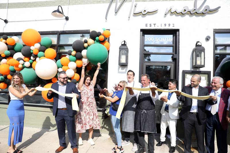 St. Charles Mayor Lora Vitek (center) cuts a 10-foot long pasta ribbon during grand opening and ribbon-cutting ceremony for Francesca's Mio Modo in St. Charles, previously known as Francesca's by the River. The restaurant reopened its doors in early August after being closed for remodeling. The restaurant also has a new menu.