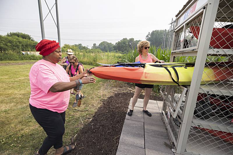 Carolann Cooper (left) helps Melinda Jones remove the kayak from the stall Wednesday, June 28, 2023.