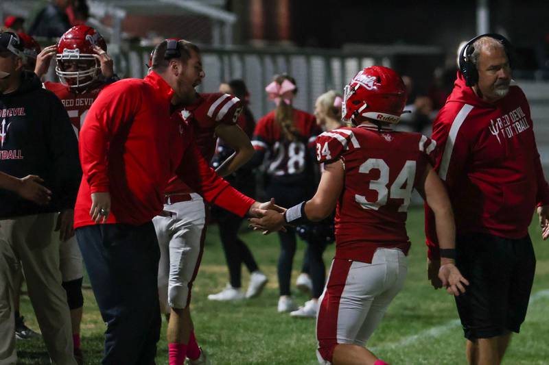 Aiden Redcliff of Hall high fives coach after scoring a touchdown against Riverdale on Friday, October 18, 2024 at Richard Nesti Stadium in Spring Valley.