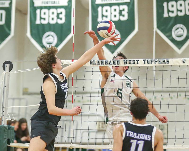 Glenbard West's Jack Anderson (6) is met at the net by Downers Grove North's Dylan Quinn (18) during volleyball match between Downers Grove North at Glenbard West.  April 2, 2024.