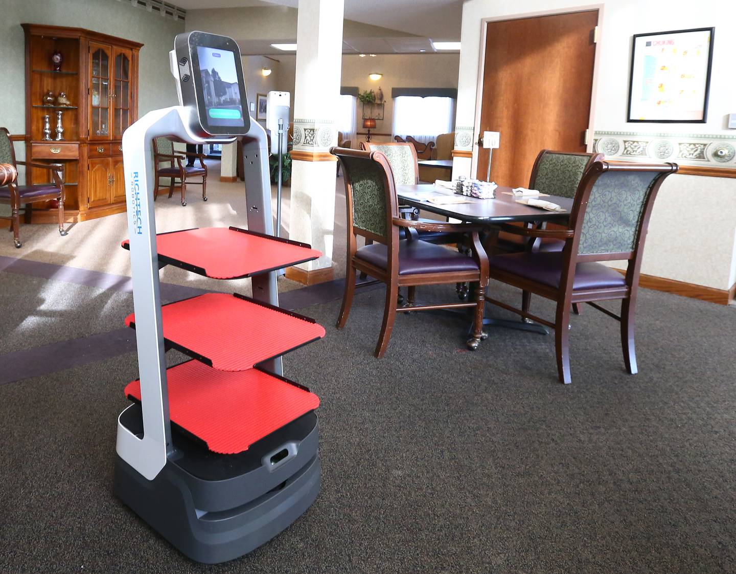 Rosie the robot roams around the dining area at Heritage Woods assisted living on Tuesday Jan. 11, 2022 in Ottawa. The robot has obstacle avoidance that will prevent any accidents as it delivers meals throughout the facility.
