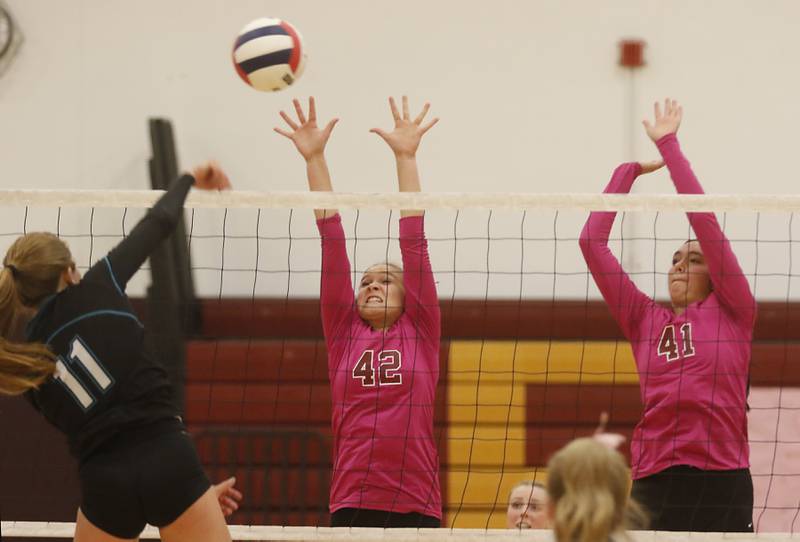 Woodstock North’s Alexis Hansen tries to hit the the ball past the block of Richmond-Burton's Zoe Freund (center) and Brianna Maldonado during a Kishwaukee River Conference volleyball match Wednesday, Oct.11, 2023, at Richmond-Burton Community High School.