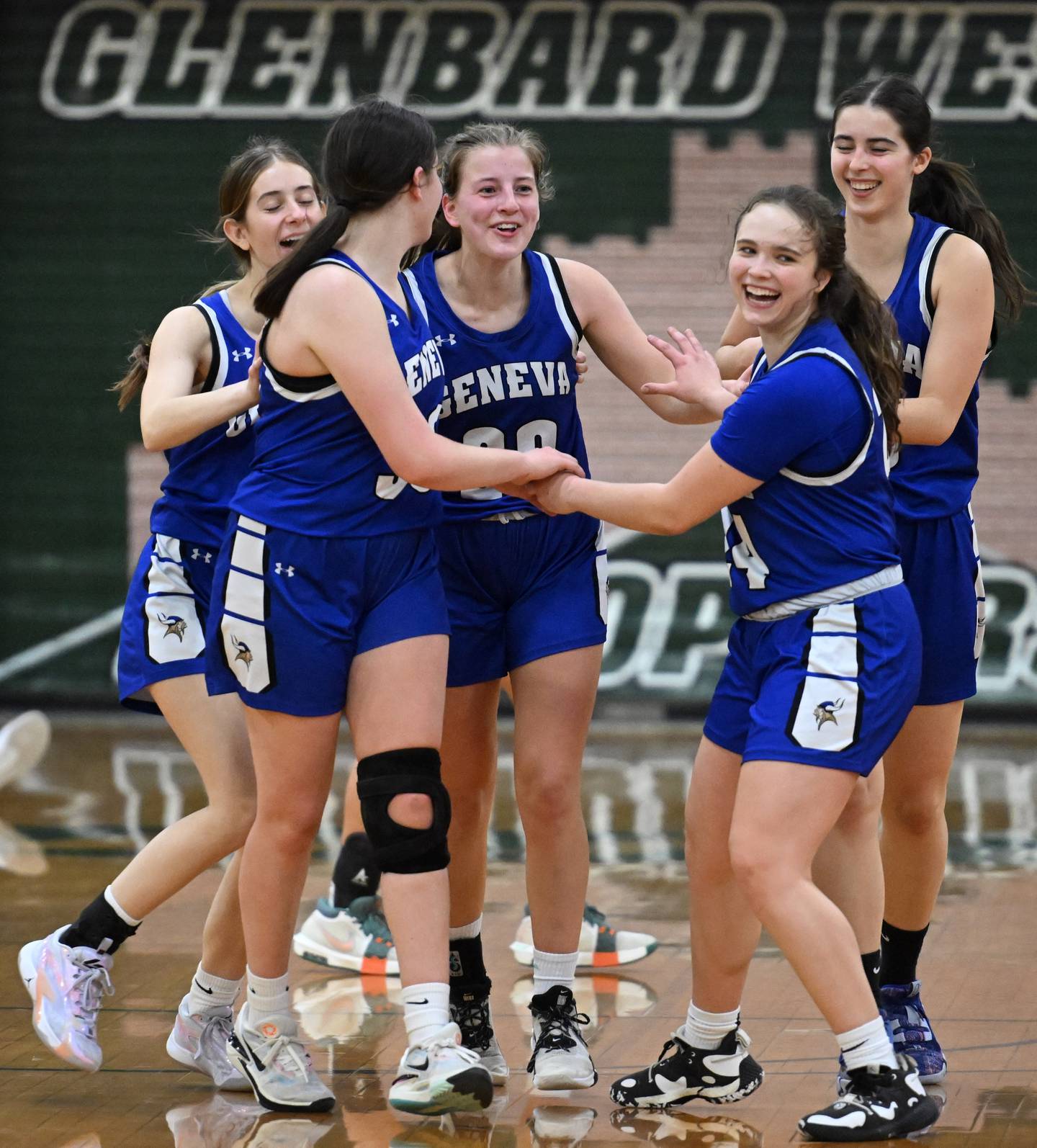 Geneva players celebrate their 45-32 victory over Glenbard West during the Glenbard West Class 4A girls basketball regional final on Thursday, Feb. 15, 2024 in Glen Ellyn.