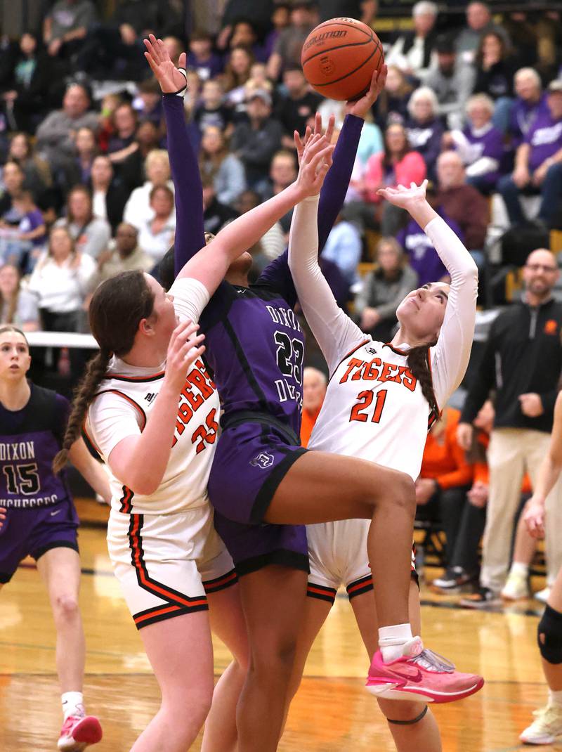 Dixon’s Ahmyrie McGowan goes after a rebound between Crystal Lake Central's Leah Spychala (left) and Reese Dambman during their Class 3A sectional semifinal Tuesday, Feb. 20, 2024, at Sycamore High School.