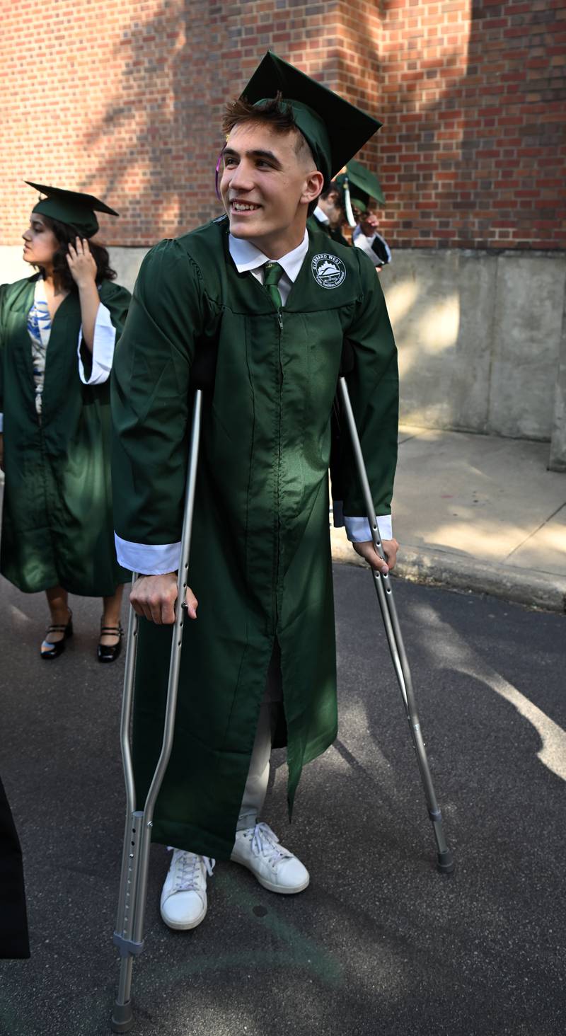 Christian Nesslar is on crutches as he awaits the start of the Glenbard West graduation ceremony on Thursday, May 23, 2024 in Glen Ellyn.