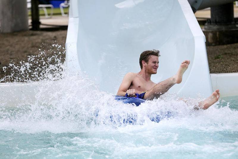 A patron slides into a pool at the end of a water slide June 20, 2016, while cooling off at Splash Station in Joliet.