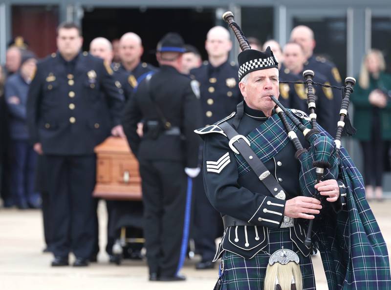 A bagpiper plays as the casket bearing the body of fallen DeKalb County Sheriff’s Deputy Christina Musil is brought to the hearse Thursday, April 4, 2024, following her visitation and funeral in the Convocation Center at Northern Illinois University.. Musil, 35, was killed March 28 while on duty after a truck rear-ended her police vehicle in Waterman.