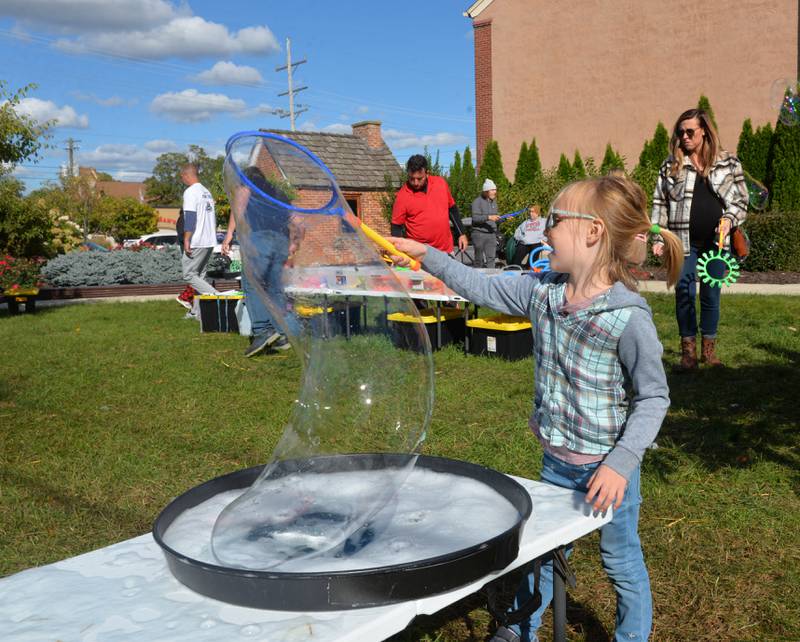 Abigail Schupbach, 5, of Byron, makes a big bubble at Autumn on Parade on Saturday, Oct. 7, 2023. The bubble show, created by Jason Kollom, was one of the free activities for kids in the Fun Zone.