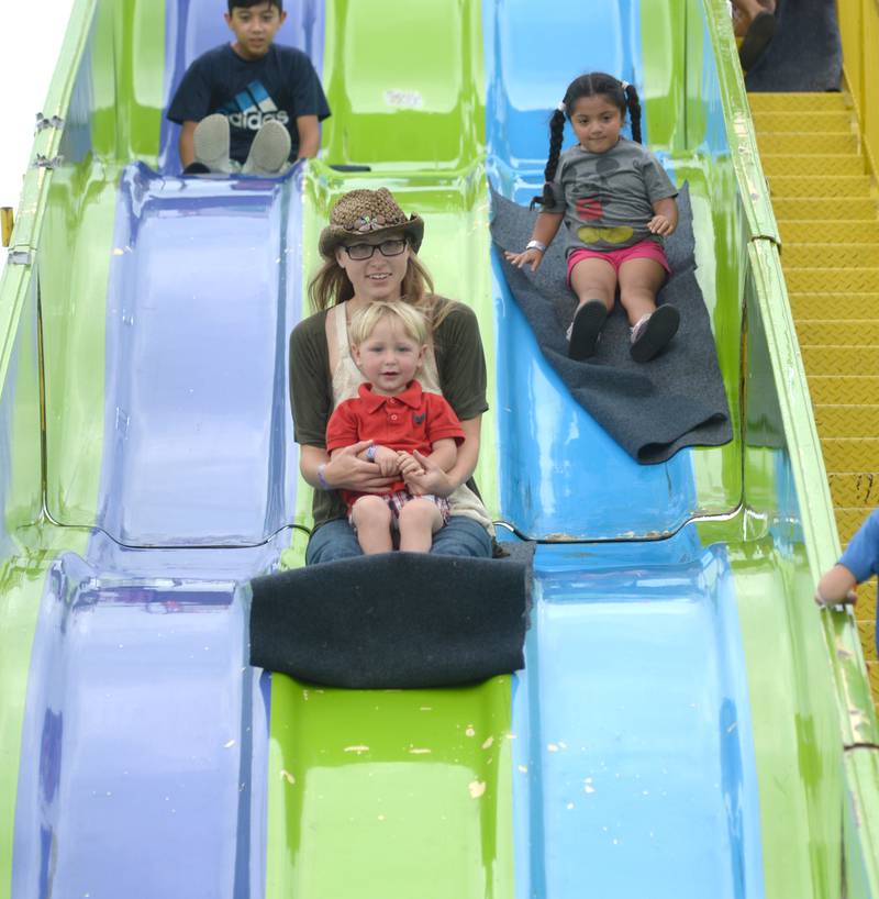 Shelly Denton of Oregon and her son Seth, 2, slide down the super slide at the Ogle County Fair on Sunday, Aug. 6, 2023.